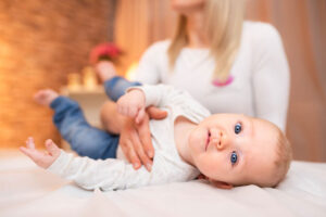 Baby laying on table with slp helping