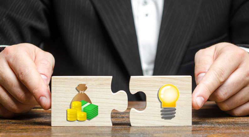 businessman putting together money and idea puzzle